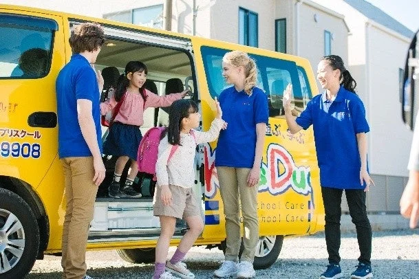 スクールバスから降りる子どもたち