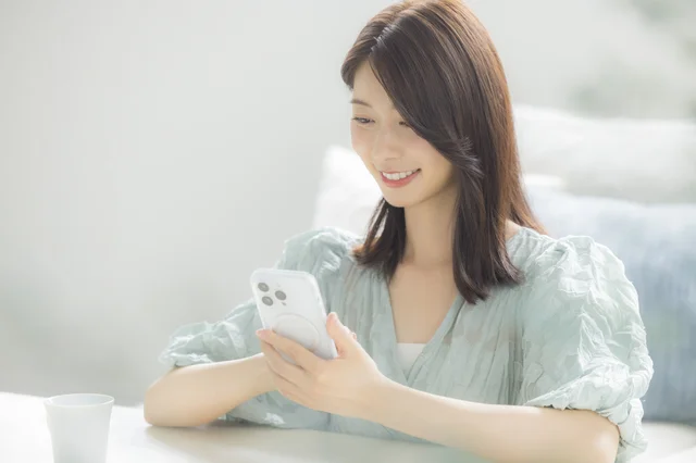 スマートフォンを操作する女性の画像